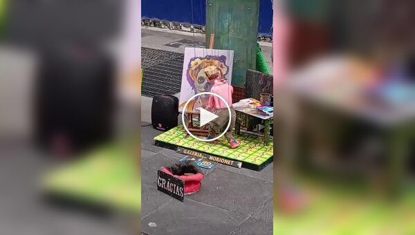 Художник рисует картины с помощью марионетки